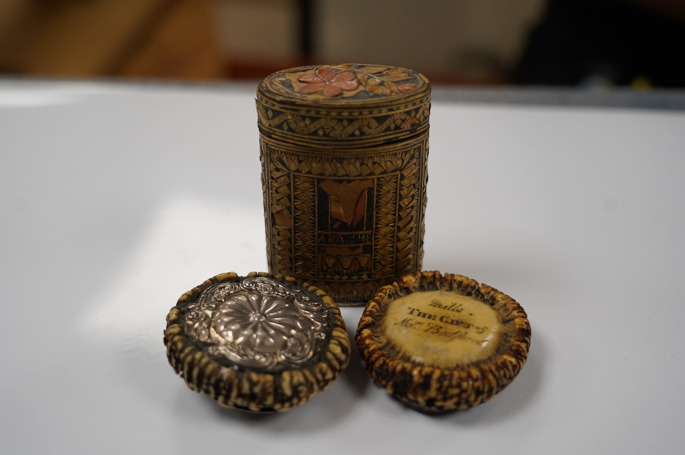 Two 19th century Scottish staghorn snuff boxes. one inscribed 'Mills, THE GIFT of Mr Bedford', with horn lid, 6.5cm, the other with white metal mounts, 6.5cm and a straw-work box, 8.5cm. Condition - staghorn boxes good,